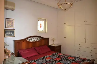a bedroom with a red bed and a window at Triple Nest Maisonette - Korydallos by ΜΡS in Piraeus