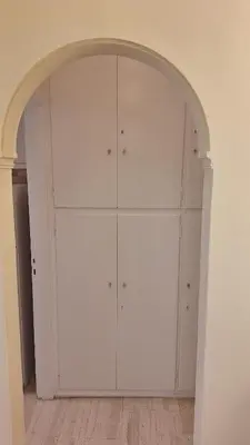 a white closet with an arch in a room at Retro Modern Apartment Pagrati in Athens