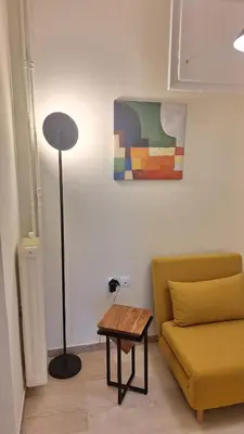 a living room with a yellow couch and a table at Retro Modern Apartment Pagrati in Athens