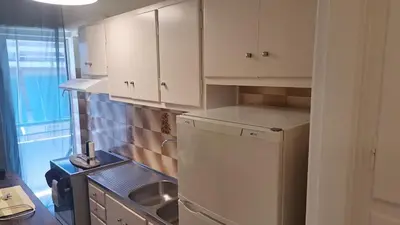 a kitchen with white cabinets and a stainless steel refrigerator at Retro Modern Apartment Pagrati in Athens