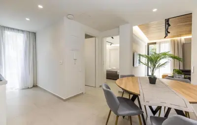a dining room with a wooden table and chairs at Aqua Vista Varkiza, Pool & Private in Vari