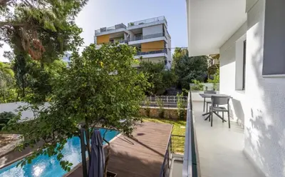 a balcony with a table and a tree on it at Aqua Vista Varkiza, Pool & Private in Vari
