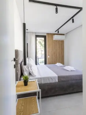 a bedroom with a large bed and a table at Aqua Vista Varkiza, Pool & Private in Vari