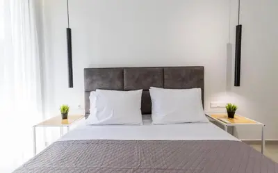 a bedroom with a large bed with white pillows at Aqua Vista Varkiza, Pool & Private in Vari