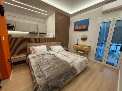 a bedroom with a bed and a desk in it at Boutique stylish studio near Dafni Metro in Athens