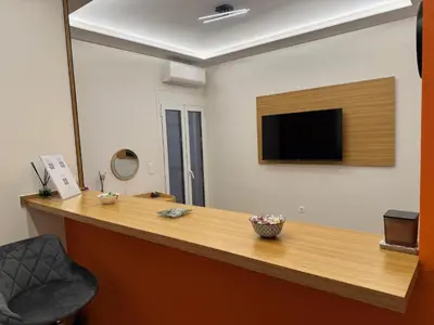 an office with a reception desk with a television on the wall at Boutique stylish studio near Dafni Metro in Athens