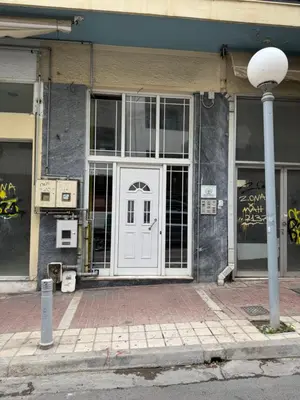 a building with a white door on a street at Boutique stylish studio near Dafni Metro in Athens