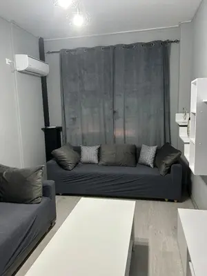 a living room with a couch in front of a window at Stylish City Apartment in Athens