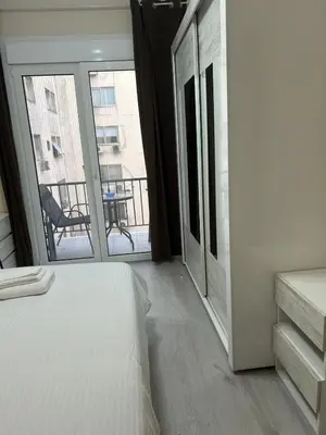 a bedroom with a bed and a large window at Stylish City Apartment in Athens