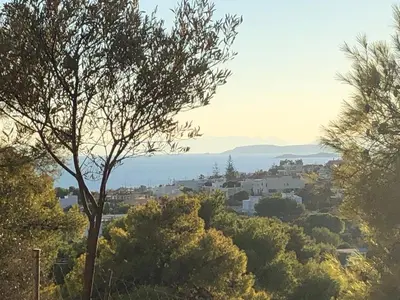 a view of a city from a hill with trees at Lagonisi Cottage - with spacious garden in Áyios Nikólaos