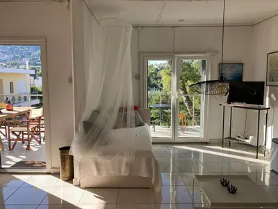 a white room with a bed with a veil at Lagonisi Cottage - with spacious garden in Áyios Nikólaos