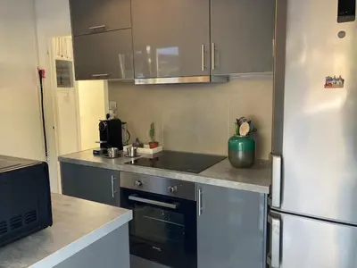a kitchen with a refrigerator and a sink at Lagonisi Cottage - with spacious garden in Áyios Nikólaos