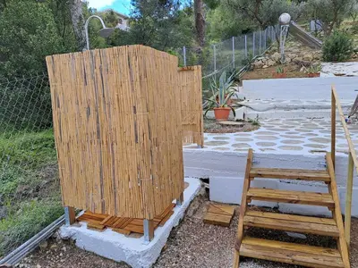 a couple of wooden chairs sitting next to a fence at Lagonisi Cottage - with spacious garden in Áyios Nikólaos