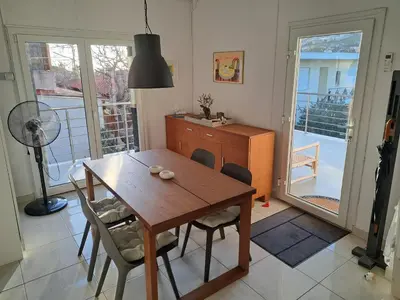 a dining room with a wooden table and chairs at Lagonisi Cottage - with spacious garden in Áyios Nikólaos