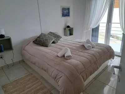 a bedroom with a large bed with towels on it at Lagonisi Cottage - with spacious garden in Áyios Nikólaos