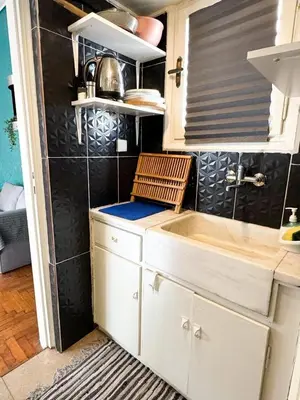 a kitchen with white cabinets and a sink at Roof top 5 steps from the beach in Athens