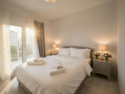 a bedroom with a white bed with towels on it at The Varkiza Residence By the Sea in Vari