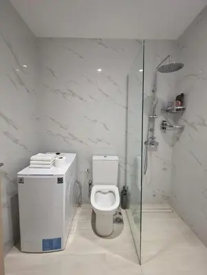 a white bathroom with a toilet and a shower at The Varkiza Residence By the Sea in Vari