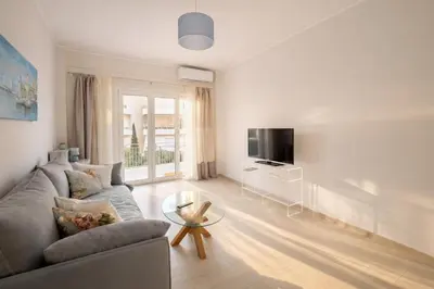 a living room with a couch and a tv at The Varkiza Residence By the Sea in Vari