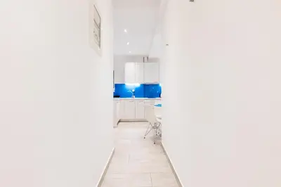 a kitchen with white cabinets and a white floor at HeKo Collection Athens 2 in Athens