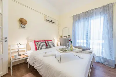 a white bedroom with a bed and a table at Stylish 1BR Retreat in Central Athens in Athens