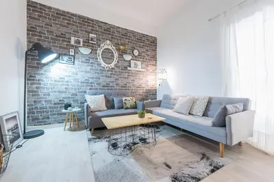 a living room with a couch and a brick wall at Stylish 1BR Retreat in Central Athens in Athens