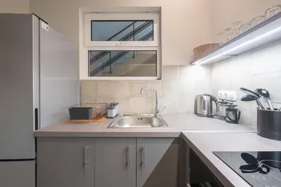 a white kitchen with a sink and a window at Zen Style, Exarchia in Athens