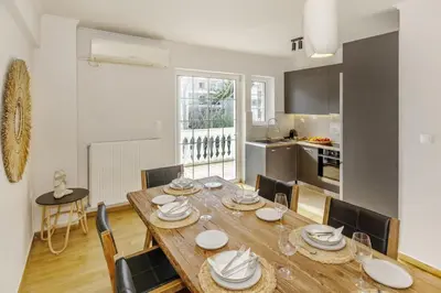 a kitchen and dining room with a wooden table and chairs at Dream House Voula in Athens