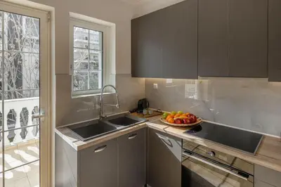 a kitchen with two sinks and a bowl of fruit at Dream House Voula in Athens