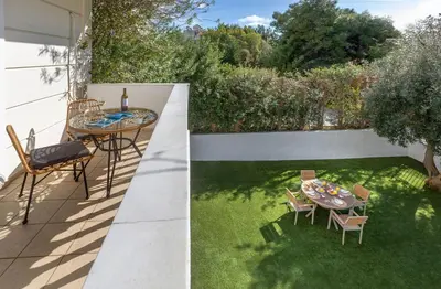a small garden with a table and chairs on a patio at Dream House Voula in Athens