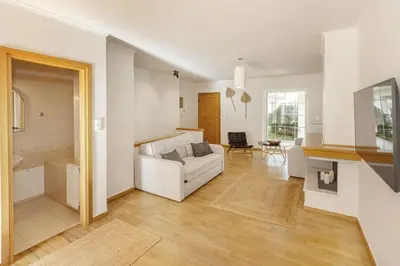 a living room with a white couch and a table at Dream House Voula in Athens