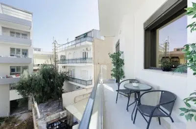 a balcony with two chairs and a table on a building at Plaza Luxury Suite, 2' from Metro, 5' from Piraeus in Piraeus