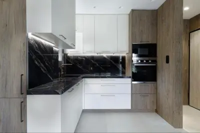 a kitchen with white cabinets and black appliances at Plaza Luxury Suite, 2' from Metro, 5' from Piraeus in Piraeus