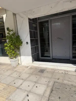 a building with a door and a potted plant in front at Plaza Luxury Suite, 2' from Metro, 5' from Piraeus in Piraeus