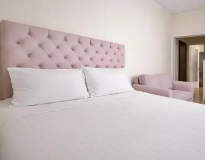 a bedroom with a large white bed with a pink headboard at Central Studio Near Uni & Parks - Zografou by ΜΡS in Athens