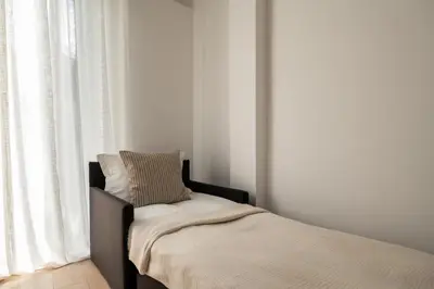 a bed with a pillow on it next to a window at CALM South 19 in Athens
