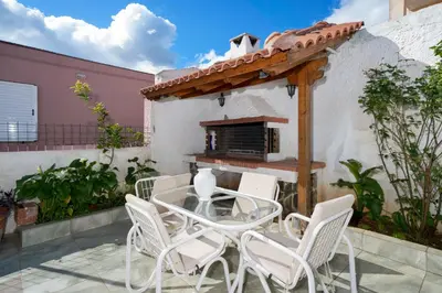 a patio with a glass table and white chairs at Porto Blue Heaven in Porto Rafti