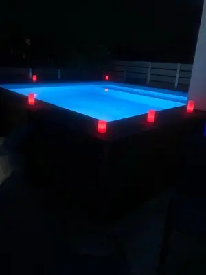 a swimming pool with red lights in the dark at Porto Blue Heaven in Porto Rafti