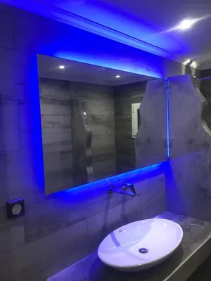 a bathroom with a sink and a mirror with blue lights at Porto Blue Heaven in Porto Rafti