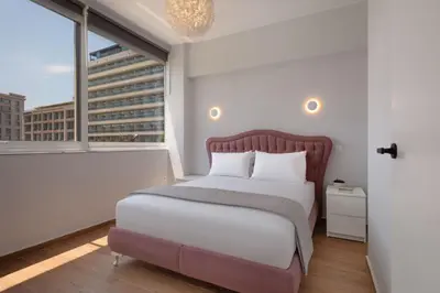 a bedroom with a bed and a large window at The White Apartment in Athens