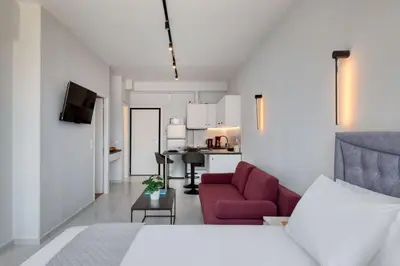 a living room with a red couch and a kitchen at The White Apartment in Athens
