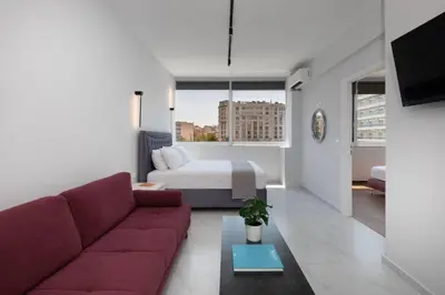 a living room with a couch and a bed at The White Apartment in Athens