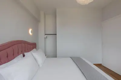 a bedroom with a white bed with a red headboard at The White Apartment in Athens