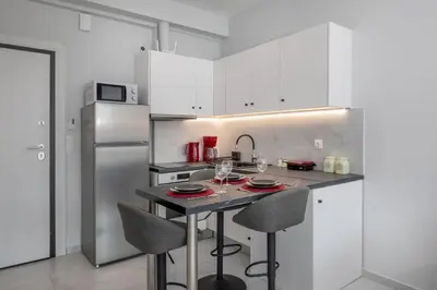 a kitchen with a table with chairs and a refrigerator at The White Apartment in Athens