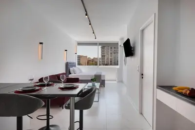 a kitchen and living room with a table and chairs at The White Apartment in Athens