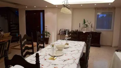 a dining room with a table with a white table cloth at Lagonisi Beach Villa in Lagonissi
