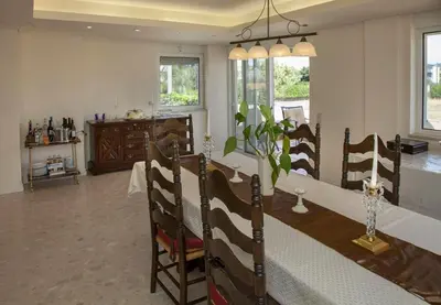 a kitchen and dining room with a table and chairs at Lagonisi Beach Villa in Lagonissi
