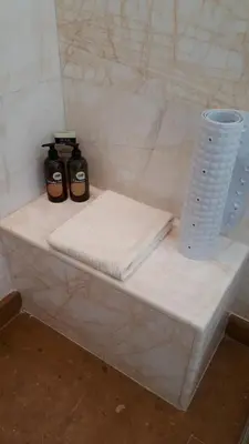 a white counter with two towels and a vase at Lagonisi Beach Villa in Lagonissi