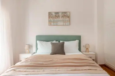 a bedroom with a large bed with a green headboard at Sunlit 3BDR Family APT, Near Sea & City Center! in Athens