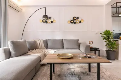 a living room with a couch and a table at Sunlit 3BDR Family APT, Near Sea & City Center! in Athens